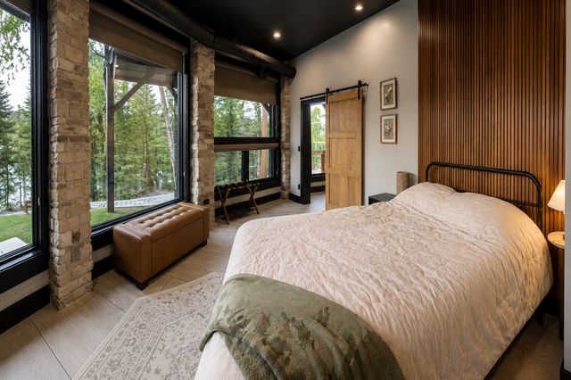 Sunset Suite, queen bed beside the stone column